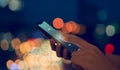 Close-up of hands scanning fingerprint on smartphone to unlock mobile phone on bokeh colors light in night atmospheric city. Royalty Free Stock Photo