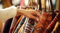 Close-up of hands selecting vintage textile shopping bag, each with distinct patterns and history. Second hand with