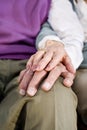 Close-up hands of senior couple resting on knee