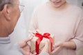 Close up hands of senior old man and his daughter giving gift box Royalty Free Stock Photo