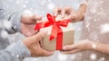 Close up hands of senior old man and his daughter giving gift box with snow background Royalty Free Stock Photo