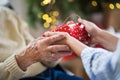 Close-up of hands of senior and young woman holding a present at Christmas.