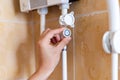 Close-up of hands setting the temperature of water in electric boiler in the shower room. Royalty Free Stock Photo