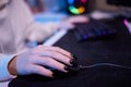 Close-up hands shot asia girl gamer use keyboard and mouse controller play video game with neon light computer in desk