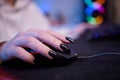 Close-up hands shot asia girl gamer use keyboard and mouse controller play video game with neon light computer in desk