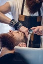 Close-up of the hands of a skilled hairdresser giving a hair wash to customer