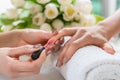 Hands of a skilled manicurist applying red nail polish on the na Royalty Free Stock Photo