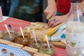 Close up of hands slicing bread for tasting at outdoor market place.