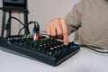 Close-up hands of sound engineer adjusting audio mixing console, tuning input and output levels, balancing sound Royalty Free Stock Photo