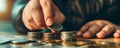 Close-up of hands stacking coins for saving