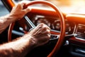 Close-up of hands on steering wheel in vintage car interior with sunlit glow Royalty Free Stock Photo