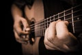 Close up hands on the strings of a guitar