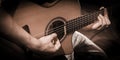 Close up hands on the strings of a guitar