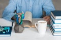 Close-up hands of the teacher man is preparing for the lesson: reading a book and making notes at the table, next to a pile of Royalty Free Stock Photo