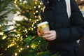 Close-up on hands of teenage girl with takeaway coffee cup on winter day. Teenager kid drinking hot beverage on chilly day Royalty Free Stock Photo