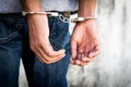 Close up hands tied up handcuffs in behind his body. Arrested man handcuffed hands at the back Royalty Free Stock Photo