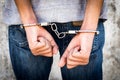 Close up hands tied up handcuffs in behind his body. Arrested man handcuffed hands at the back Royalty Free Stock Photo