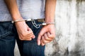 Close up hands tied up handcuffs in behind his body. Arrested man handcuffed hands at the back Royalty Free Stock Photo