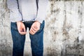 Close up hands tied up handcuffs in behind his body. Arrested man handcuffed hands at the back Royalty Free Stock Photo