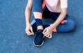 Close up of hands touching running shoes and legs woman sitting on the street. Royalty Free Stock Photo