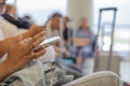 Close up hands of traveller or tourist using smartphone for connecting people in airport shows blurred background of tourist Royalty Free Stock Photo