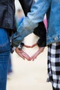 Close-up of the hands of two friends forming a heart.