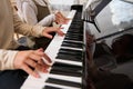 Close-up of the hands of a boy and girl playing music on grand piano. Kids fingers on ebony and ivory keys. Music lesson Royalty Free Stock Photo