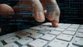 Close-up of Hands Typing on a Computer Keyboard with Code and Digital Data Overlay Representing Technology, Programming Royalty Free Stock Photo