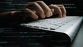 Close-up of Hands Typing on a Computer Keyboard with Programming Code in the Background Representing Software Royalty Free Stock Photo