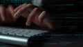 Close-Up of Hands Typing on a Computer Keyboard Surrounded by Lines of Code in a Dark Environment Featuring Technology Royalty Free Stock Photo