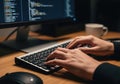 Close up of hands typing on a keyboard with computer code on the screen Royalty Free Stock Photo