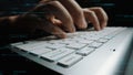 Close-up of hands typing on a keyboard with digital code and binary data overlay, symbolizing technology, coding, and Royalty Free Stock Photo