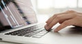 Close-up of hands typing on a laptop keyboard with code on screen Royalty Free Stock Photo