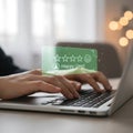 Hands typing on laptop with customer satisfaction rating and happy user feedback review Royalty Free Stock Photo