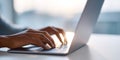 Close-up of hands typing on laptop keyboard with soft natural light in modern workspace environment Royalty Free Stock Photo
