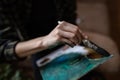 Close up on hands of unknown female artist caucasian woman or girl painting on canvas using brush and colors to make art Royalty Free Stock Photo