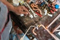 Close up on hands of unknown industrial worker plumber with central heating copper pipes welding using gas torch or blowtorch at Royalty Free Stock Photo