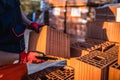 Close up on hands of unknown man construction worker taking hollow clay block ar warehouse or construction site in sunny summer Royalty Free Stock Photo