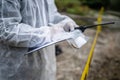 Close up on hands of unknown man crime scene detective inspector during investigation collecting evidence on the crime scene