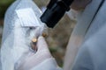 Close up on hands of unknown man forensic police investigator collecting evidence in the plastic bag at the crime scene Royalty Free Stock Photo