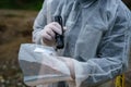 Close up on hands of unknown man forensic police investigator collecting evidence in the plastic bag at the crime scene Royalty Free Stock Photo