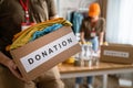 Close up on hands of unknown man volunteer working at the charity foundation holding box with clothes and stuff for donation copy