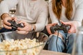 Close up on hands of unknown man and woman holding video game console controller Royalty Free Stock Photo