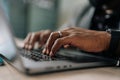 Close-up hands of unrecognizable black businessman working on laptop at home office. Young African student or remote Royalty Free Stock Photo