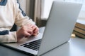 close-up hands unrecognizable child boy typing text using keyboard laptop sitting at desk with near window.