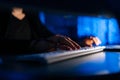 Close-up hands of unrecognizable hacker man working typing on keyboard laptop computer sitting at desk in dark room with Royalty Free Stock Photo