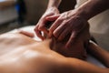 Close-up hands of unrecognizable male massage therapist gently massaging neck of woman with beautiful skin and shiny Royalty Free Stock Photo