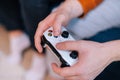 Close-up hands of unrecognizable man holding joystick and playing video games on console at home. Royalty Free Stock Photo