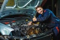 Close up hands of unrecognizable mechanic doing car service and maintenance Royalty Free Stock Photo