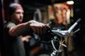 Close-up hands of unrecognizable mechanic insisting speed switches on mountain bike handlebar working in bicycle repair Royalty Free Stock Photo